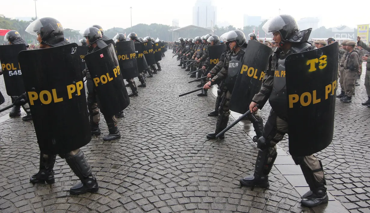 Satuan Polisi Pamong Praja menampilkan simulasi demo pertahanan dalam rangka perayan HUT Satpol PP ke-68 di Monas, Jakarta, Kamis (26/4). Gubernur DKI Anies Baswedan bertindak sebagai Inspektur Upacara HUT Satpol PP itu. (Liputan6.com/Arya Manggala)