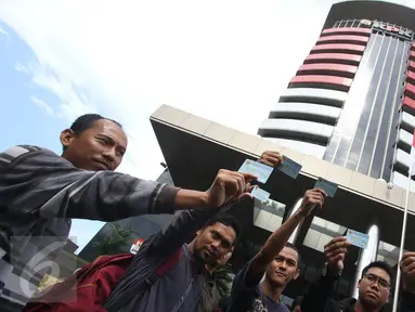 Aktivis Koalisi Masyarakat Sipil menunjukan Kartu Tanda Penduduk (KTP) Elektronik saat melakukan aksi di depan Gedung Komisi Pemberantasan Korupsi (KPK), Jakarta, Minggu (12/3). (Liputan6.com/Immanuel Antonius)
