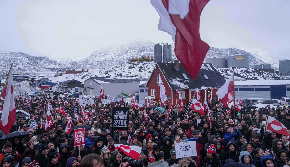 Sebelumnya, Presiden Amerika Serikat (AS), Donald Trump, menyatakan Greenland penting bagi keamanan nasional AS karena posisinya yang strategis di kawasan Arktik serta kekayaan sumber daya mineralnya. Tampak dalam foto, warga berdemonstrasi menentang kebijakan Presiden Amerika Serikat (AS), Donald Trump, terhadap Greenland di depan konsulat AS di Nuuk, Sabtu 17 Januari 2026. (AP Photo/Evgeniy Maloletka)