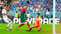 Pemain Portugal Cristiano Ronaldo (tengah) berusaha mencetak gol ke gawang Uruguay pada pertandingan sepak bola Grup H Piala Dunia 2022 di Stadion Lusail, Lusail, Qatar, 28 November 2022. Portugal mengalahkan Uruguay dengan skor 2-0. (AP Photo/Petr David Josek)