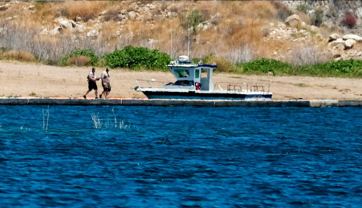 Anggota sheriff Ventura County terlihat di dermaga berperahu di Danau Piru, California, Senin (13/7/2020). Kepolisian wilayah Ventura pada Senin (13/7) pagi mengumumkan telah mengangkat jasad  Naya Rivera dari Danau Piru.  (AP/Ringo H.W. Chiu)