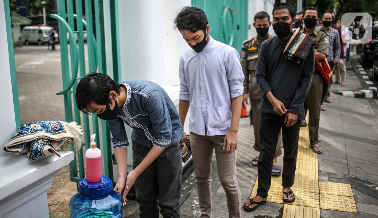 Umat Muslim mencuci tangan sebelum memasuki Masjid Cut Meutia untuk melaksanakan salat Jumat di Jakarta Pusat, Jumat (5/6/2020). Masjid Cut Meutia kembali menyelenggarakan ibadah salat Jumat dalam masa PSBB transisi dengan menerapkan protokol kesehatan secara ketat. (Liputan6.com/Faizal Fanani)