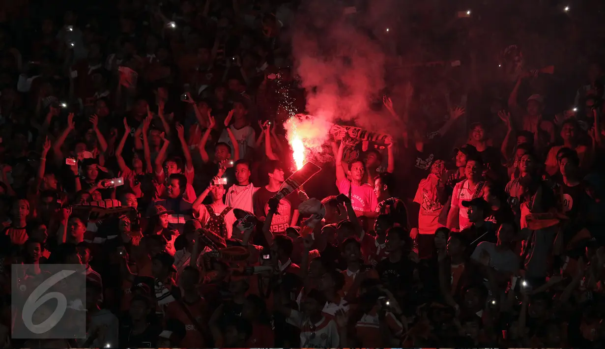 Suporter tim Macan Kemayoran menyalakan flare saat menyaksikan laga Persija melawan Semen Padang di Torabika Soccer Championship presented by IM3 Ooredoo di Stadion GBK, Jakarta, Minggu (8/5/2016). Persija unggul 1-0. (Liputan6.com/Helmi Fithriansyah)