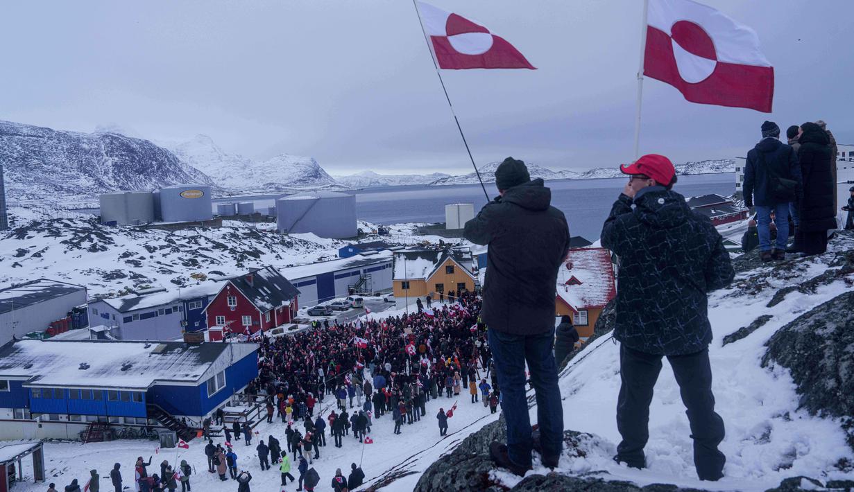 Ratusan orang turun ke jalan pada Sabtu (17/1/2026) berunjuk rasa dengan mendatangi konsulat Amerika Serikat (AS) di Nuuk, Greenland. Tampak dalam foto, warga berdemonstrasi menentang kebijakan Presiden Amerika Serikat (AS), Donald Trump, terhadap Greenland di depan konsulat AS di Nuuk, Sabtu 17 Januari 2026. (AP Photo/Evgeniy Maloletka)