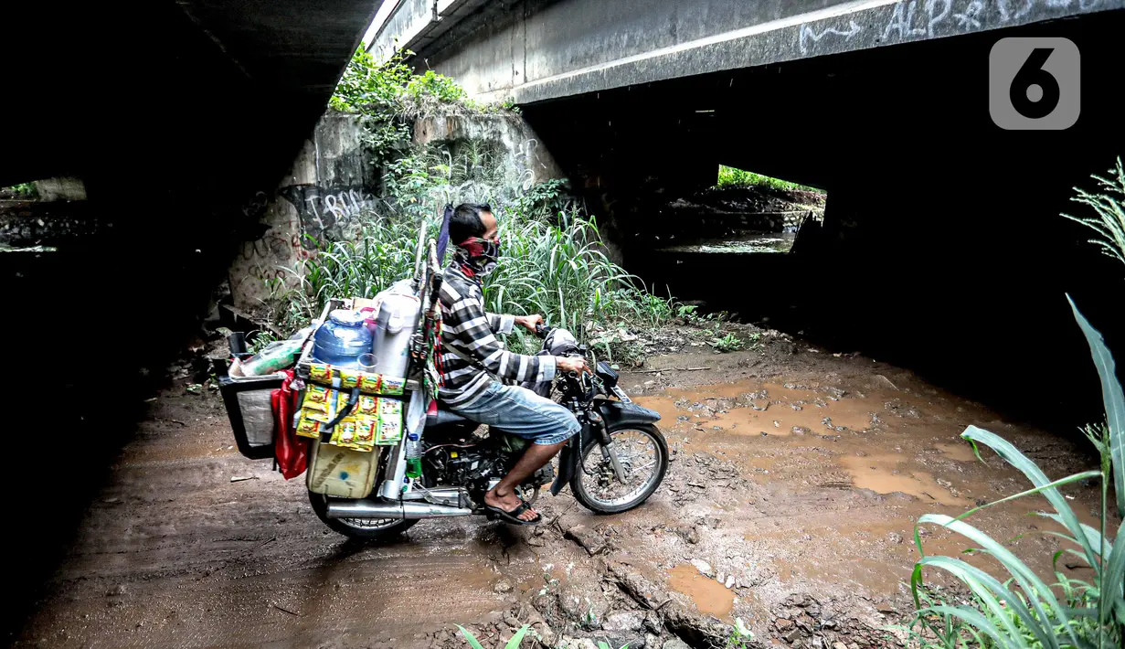 Pengendara sepeda motor melintas di kolong Tol Jagorawi, Cimanggis, Depok, Jawa Barat, Minggu (8/11/2020). Buruknya jalan dan minimnya penerangan membuat akses tersebut rawan aksi kejahatan. (Liputan6.com/Faizal Fanani)