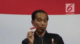 Presiden Joko Widodo menunjukkan Kartu Keluarga Sejahtera saat menghadiri sosialisasi Bansos Program Keluarga Harapan (PKH) Tahun 2019 di Gelanggang Remaja, Jakarta, Senin (3/12). (Liputan6 com/Angga Yuniar)