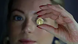 Seorang karyawan Dix Noonan Webb menunjukkan koin Romawi kuno di London, Inggris (28/5/2019). Koin emas ini diperkirakan akan mendapatkan jumlah enam angka ketika itu ditawarkan oleh Dix Noonan Webb dalam lelang dua hari mereka pada bulan Juni. (AP Photo/Kirsty Wigglesworth)