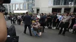 Seorang pria korban ambruknya balkon BEI duduk dikursi roda saat dievakuasi petugas medis di Jakarta, Senin (15/1). Puluhan korban dievakuasi ke rumah sakit terdekat, yaitu RS Siloam dan RS Mintoharjo. (Liputan6.com/Arya Manggala)