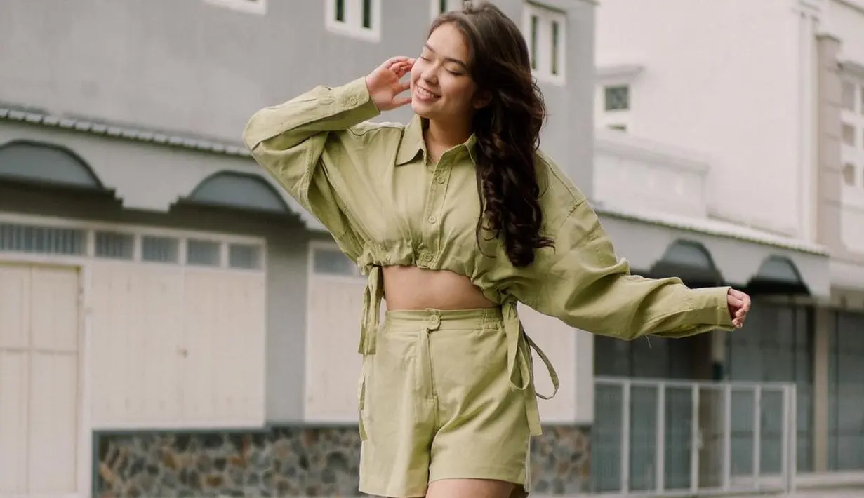 Tampil manis dalam balutan outfit berwarna olive green. Crop top berkerah dan lengan panjang dipadu dengan set short pantsnya yang serasi, serta sneakers favorit. Foto: Instagram.