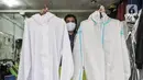 Pekerja menunjukkan berbagai jenis baju hazmat yang dijual di salah satu industri konveksi Pusat Industri Kecil (PIK), Jakarta, Rabu (30/12/2020). Selain pesanan langsung, baju hazmat kini laris dijual melalui online shop. (merdeka.com/Iqbal S. Nugroho)