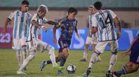 Pemain Timnas Jepang U-17, Ryunosuke Sato (tengah) berebut bola dengan pemain Timnas Argentina U-17, Maher Carrizo pada laga kedua Grup D Piala Dunia U-17 2023 di Stadion Si Jalak Harupat, Kabupaten Bandung, Selasa (14/11/2023). (Bola.com/Ikhwan Yanuar)