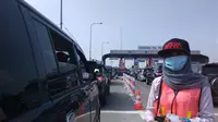 Petugas gerbang Tol Pejagan 'jemput bola' menghampiri mobil-mobil yang antre keluar tol (Audrey Santoso/Liputan6.com)