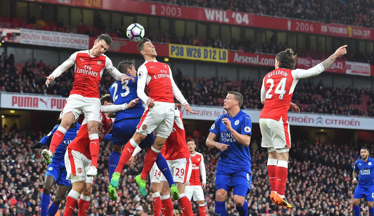 Para pemain Arsenal dan Leicester melakukan duel udara pada laga Premier League di Stadion Emirates, London, Rabu (26/4/2017). Arsenal menang 1-0 atas Leicester. (AFP/Glyn Kirk)