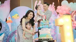 Saat momen potong kue ultah, Dory Harsa tampak terus menggendong putri bungsunya. Sementara itu, Nella mewakilkan Kenes memotong kue bersama dengan anak sulungnya, Gendhis yang tampak antusias. Seperti diketahui, Kenes lahir saat Gendhis belum genap berusia 2 tahun. Adik kakak itu pun punya jarak usia yang berdekatan. (Liputan6.com/IG/@nellakharisma)