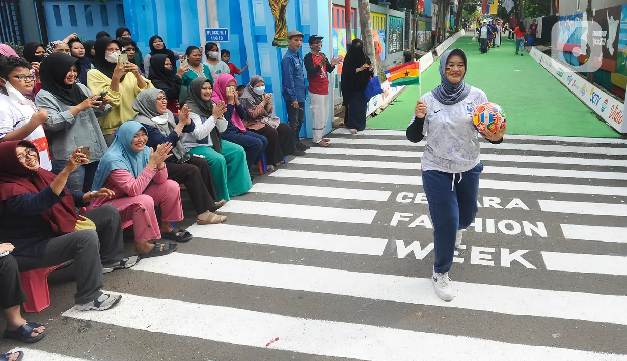 Warga dengan mengenakan jersey atau kostum tim sepak bola peserta Piala Dunia 2022 Qatar menggelar fashion show di Perum Depok Maharaja Blok M1 Cluster Cemara, Rangkapan Jaya, Depok, Minggu (20/11/2022). Fashion show jelang Piala Dunia 2022 terlihat mendapat sambutan antusias warga Perum Depok Maharaja Blok M1 Cluster Cemara yang menyaksikan acara tersebut. (merdeka.com/Arie Basuki)