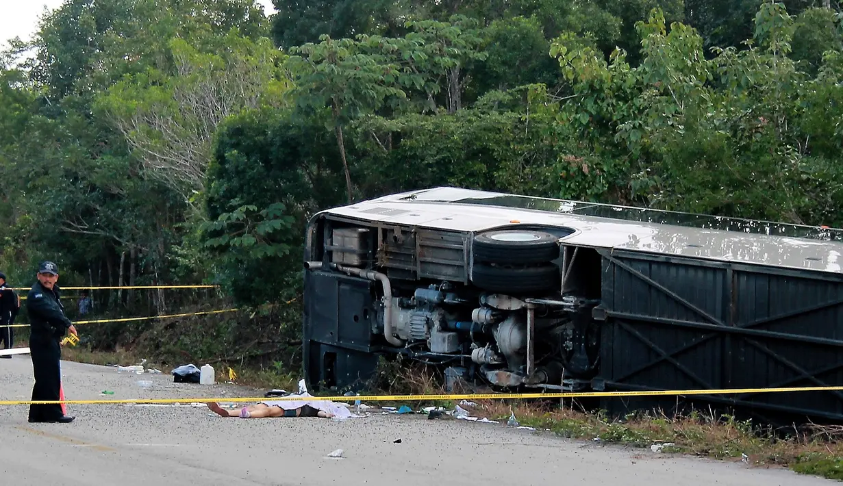 Jasad penumpang tergeletak di dekat bus wisata yang terbalik di jalan raya Mahahual di Quintana Roo, Meksiko, Selasa (19/12). Sedikitnya 12 turis tewas, satu di antaranya anak-anak, dan 18 lainnya mengalami luka-luka. (Novedades de Quintana Roo via AP)