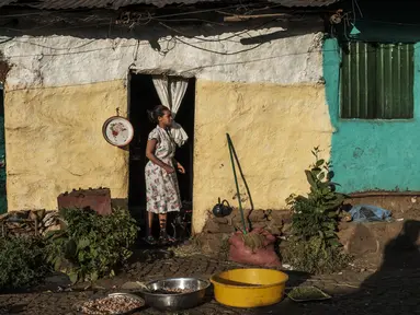 Seorang perempuan berdiri di depan pintu sebuah rumah di Kota Gondar, Ethiopia pada 09 November 2020. (Photo by EDUARDO SOTERAS / AFP)