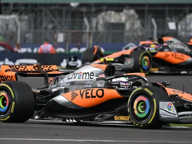 Pembalap McLaren, Lando Norris dan Oscar Piastri memacu mobilnya saat balapan Formula 1 GP Inggris di Sirkuit Silverstone, Inggris, 9 Juli 2023. (AFP/Andrej Isakovic)