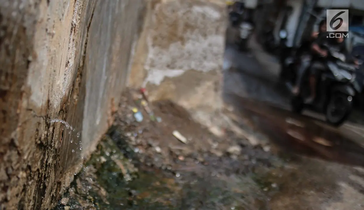 Air mengucur dari tanggul pengaman pantai yang bocor di kawasan Muara Baru, Jakarta, Selasa (11/12). Tanggul pengaman pantai untuk mencegah banjir rob di kawasan tersebut bocor karena tingginya volume pasang surut air laut. (Liputan6.com/Faizal Fanani)
