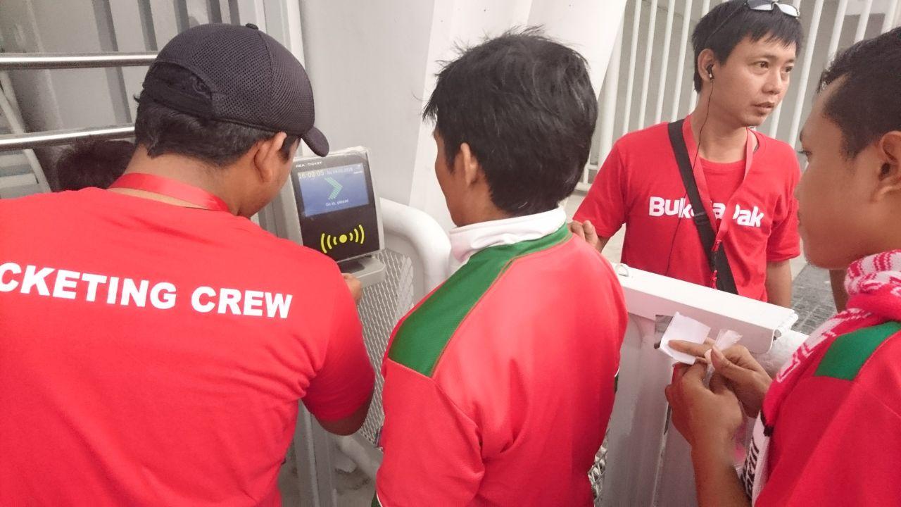 Momen ketika seorang suporter mencoba memasukan tiket menggunakan barcode scanner. (Bola.com/Muhammad Ivan Rida)