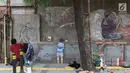 Seorang pria membuat sketsa di depan Kampung Tematik Sketsa di kawasan Penjaringan, Jakarta Utara, Rabu (1/7). Sketsa-sketsa yang menghiasi kawasan tersebut dibuat dalam rangka menyambut Asian Games XVIII Tahun 2018. (Liputan6.com/Immanuel Antonius)