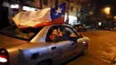 Suporter Chili mengibarkan bendera nasional dari mobil saat merayakan kemenangan Chile atas Peru di semifinal Copa America 2015 l di Concepcion, Chili, (29 /6/2015). Chile melaju ke final usai mengalahkan Peru 2-1. (REUTERS/Carlos Garcia Rawlins)