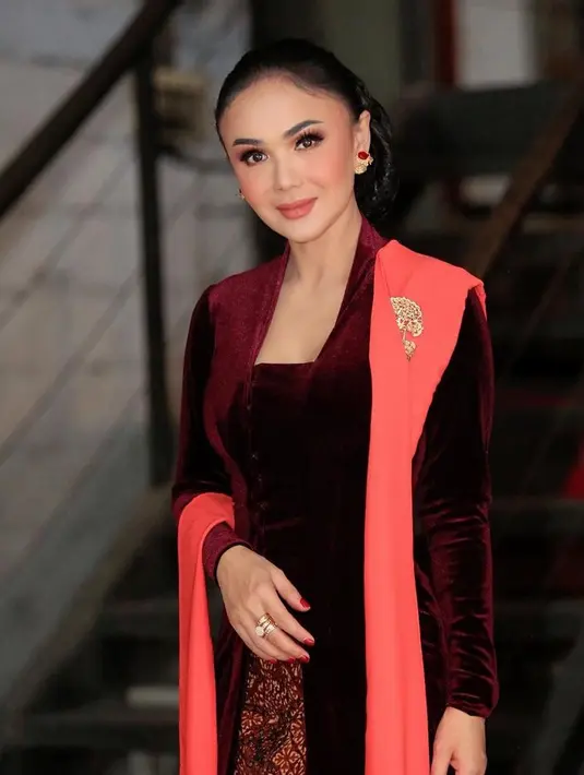 Yuni Shara tampil elegan dengan sanggul klasik tanpa aksesori dipadukan anting subeng dan kebaya velvet maroon dengan selendangnya. [@yunishara36]