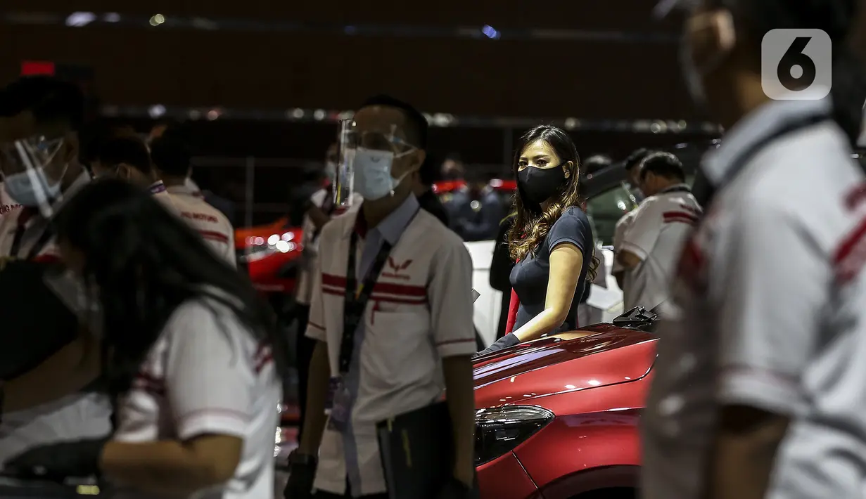 SPG berdiri dekat mobil yang dipamerkan di Indonesia International Motor Show (IIMS) Hybrid 2021, JiExpo Kemayoran, Jakarta, Kamis (16/4/2021). Acara digelar secara daring dan kunjungan langsung dengan pembatasan kapasitas dan penerapan protokol kesehatan COVID-19. (Liputan6.com/JohanTallo)