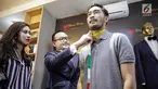 Syahnaz Sadiqah melihat calon suaminya Jeje Govinda saat fetting jas di Wong Hang Tailor di Jakarta, Rabu (7/2). Kedatangan mereka untuk fitting jas pernikahan yang akan dikenakan oleh Jeje Govinda dalam pernikahan nanti. (Liputan6.com/Faizal Fanani)