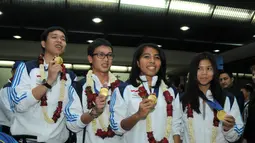 Pebulutangkis ganda putra dan putri peraih emas Asian Games 2014, Hendra Setiawan/Mohammad Ahsan dan Nitya Krishinda/Greysia Polii (dari kiri ke kanan) berpose di Bandara Soekarno-Hatta, Selasa (30/9/2014). (Liputan6.com/Helmi Fithriansyah)