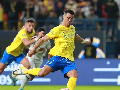 Pemain Al Nassr, Cristiano Ronaldo, menendang bola dari titik penalti yang membuahkan gol ke gawang Al Ettifaq dalam pertandingan lanjutan Saudi Pro League 2023/2024 yang berlangsung di Al Awwal Park, Jumat (22/12/2023). (X/Al Nassr FC)