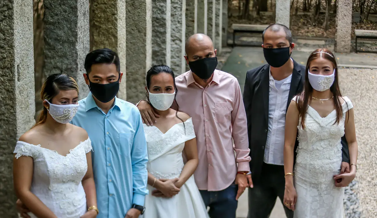 Para pasangan mengenakan masker terlihat dalam "pernikahan massal bermasker" di sebuah taman di Kota Makati, Filipina (15/12/2020). Pemerintah Filipina telah memberlakukan kebijakan untuk penggunaan masker di tengah kekhawatiran lonjakan kasus COVID-19 selama musim liburan. (Xinhua/Rouelle Umali)