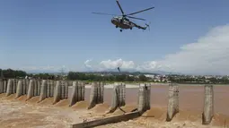 Prajurit Angkatan Udara India turun dari helikopter untuk menyelamatkan para nelayan yang terperangkap dalam banjir di Sungai Tawi di Jammu, India (19/8/2019). Permukaan air di banyak sungai di India utara meningkat setelah hujan lebat di musim hujan. (AP Photo/Channi Anand)