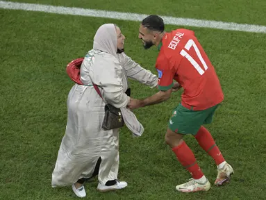 Gelandang Maroko #17 Sofiane Boufal merayakan bersama ibunya setelah lolos ke semifinal dengan mengalahkan Portugal pada babak 8 besar Piala Dunia 2022 di Stadion Al-Thumama di Doha, Sabtu (10/12/2022). Sofiane Boufal melakukan selebrasi dansa ditemani ibunya usai Maroko menang 1-0 atas. (JUAN MABROMATA / AFP)