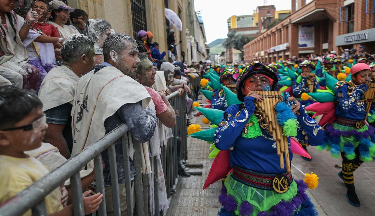 Orang-orang menikmati saat para peserta melakukan parade "Nyanyian untuk Bumi", pada tanggal 3 Januari 2024. (JOAQUIN SARMIENTO/AFP)