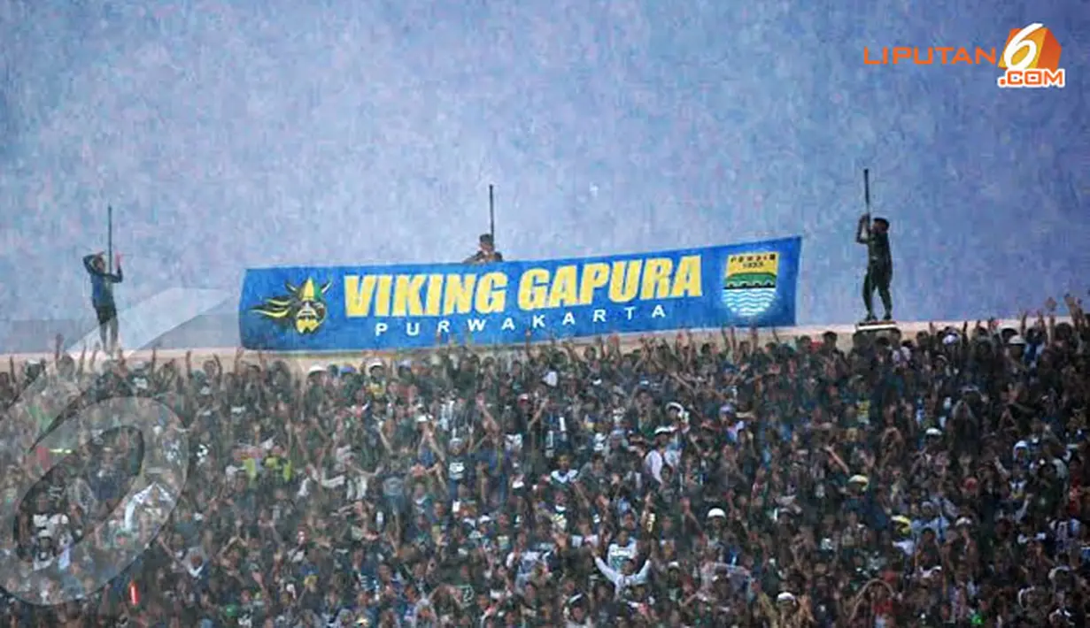Meski berada di bawah guyuran hujan semangat bobotoh tetap membara mendukung Persib Bandung yang berlaga melawan DC United (Liputan6.com/Helmi Fithriansyah)