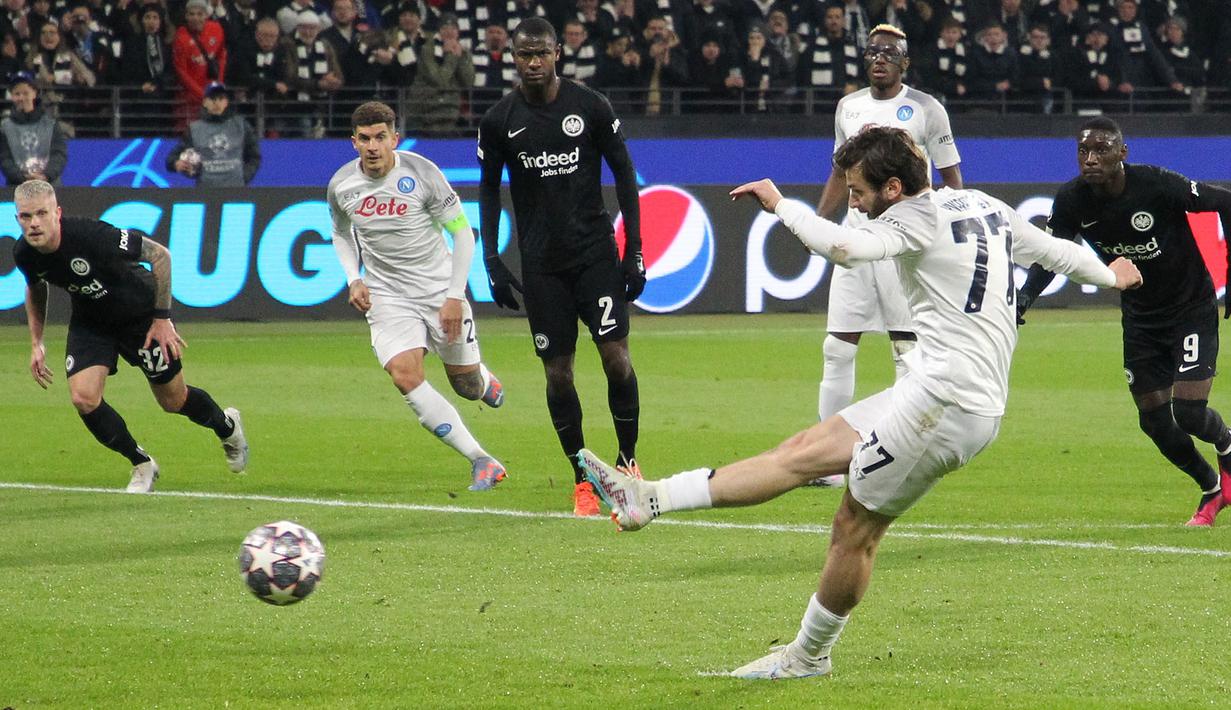 <p>Pemain Napoli, Khvicha Kvaratskhelia berusaha mencetak gol dari tendangan penalti ke gawang Eintracht Frankfurt pada laga leg pertama 16 besar Liga Champions 2022/2023 yang berlangsung di Deutsche Bank Park, Rabu (22/2/2023) WIB. (AFP/Daniel Roland)</p>