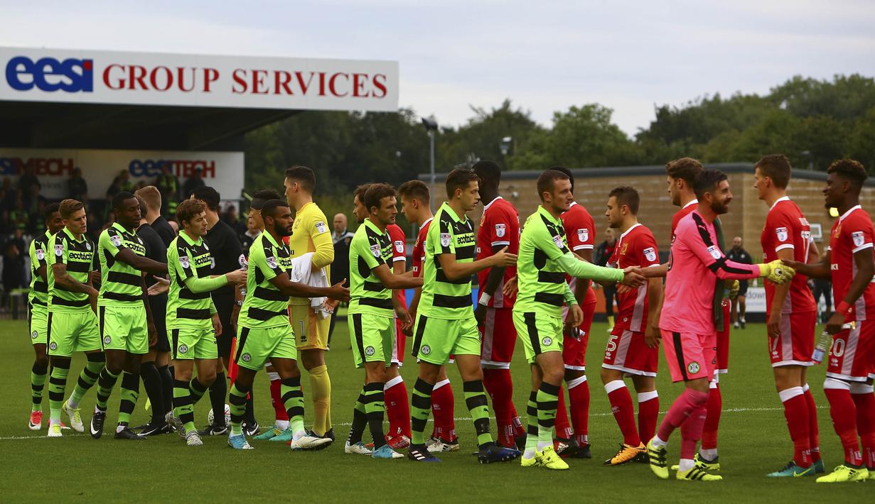 Para pemain Forest Green Rovers bersalaman dengan pemain MK Dons pada laga Piala Liga di Stadion New Lawn, Nailsworth, Selasa (8/8/2017). FGB merupakan klub sepak bola yang mengedepankan hidup sehat dan ramah lingkungan. (AFP/Geoff Caddick)