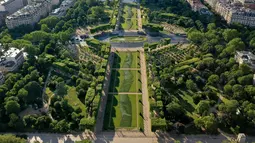 Foto udara dari lukisan raksasa "Beyond Walls" karya seniman jalanan Prancis, Saype, yang terbentang di halaman Champs de Mars, depan Menara Eiffel di Paris, 13 Juni 2019. Menggunakan cat ramah lingkungan, lukisan itu bergambar seperti tangan-tangan raksasa saling bergandengan. (Eric FEFERBERG/AFP)