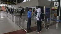 Petugas mengecek suhu tubuh calon penumpang di Terminal 1 A Bandara Internasional Soekarno Hatta, Tangerang, Sabtu (28/3/2020). PT Angkasa Pura II (Persero) akan membatasi kegiatan di Terminal 1 dan 2 Bandara Soetta mulai 1 April 2020 terkait meluasnya kasus Corona.  (Liputan6.com/Herman Zakharia)