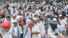 Puluhan orang berjalan kaki menuju Monas dari arah Tanah Abang, Jakarta, Jumat (2/12). Mereka terlihat berbondong-bondong berjalan untuk mengikuti demo 2 Desember di Lapangan Monas. (Liputan6.com/Helmi Afandi)