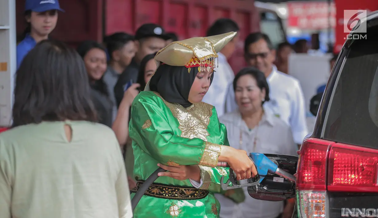 Petugas SPBU mengenakan pakaian adat mengisi bahan bakar minyak (BBM) ke sebuah mobil di kawasan Kelapa Gading, Jakarta, Senin (22/4). Dalam rangka memperingati Hari Kartini pengelola SPBU mengajak Seluruh pegawai SPBU mengenakan mengenakan baju kebaya dan baju adat. (Liputan6.com/Faizal Fanani)