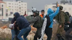 Polisi Israel menangkap seorang demonstran Palestina di kota Ramallah, Tepi Barat, (13/12). Sejumlah Polisi Israel menangkap warga Palestina dengan menyamar sebagai demonstran. (AP Photo / Nasser Shiyoukhi)