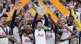 Son Heung-min (tengah) mengangkat trofi bersama para pemain Tottenham setelah menjuarai final Liga Europa 2024/2025 di Stadion San Mames, Bilbao, Spanyol, Kamis (22/05/2025) WIB. Tottenham menang dengan skor 1-0 atas Manchester United. (AFP/Thomas Coex)