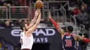 Aksi pemain Cleveland Cavaliers, Kevin Love (0) mencetak poin saat diadang pemain Wizards, Mike Scott (30) pada laga NBA basketball game di Capital One Arena, Washington, (17/12/2017). Cleveland menang 106-99. (AP/Nick Wass)