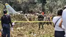 Komandan Angkatan Udara Kolombia, Jenderal Carlos Silva, mengatakan bahwa pesawat itu mengangkut 114 penumpang dan 11 awak. Tampak dalam foto, warga dan tentara berdiri di dekat puing-puing pesawat Hercules Angkatan Udara yang jatuh saat lepas landas, di Puerto Leguizamo, Kolombia, dekat perbatasan selatan dengan Ekuador, pada 23 Maret 2026. (Daniel Ortiz/AFP)