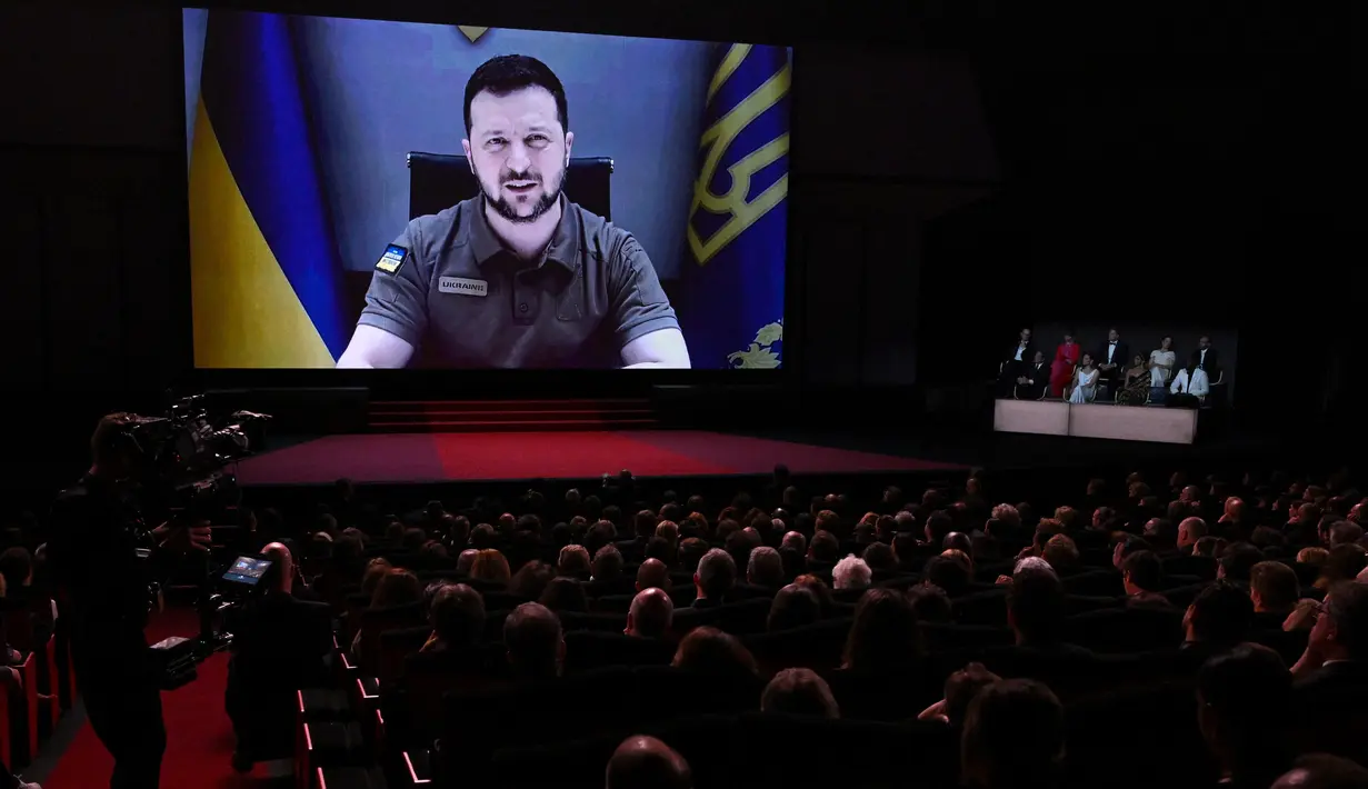 Presiden Ukraina Volodymyr Zelensky menyampaikan pidato lewat video yang disetel saat upacara pembukaan Festival Film Cannes edisi ke-75 di Cannes, Prancis selatan, Selasa (17/5/2022).  (AFP/CHRISTOPHE SIMON)