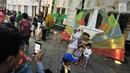 Pengunjung berfoto dengan manusia patung dan berkostum di kawasan Kota Tua, Jakarta, Selasa (27/6). Mereka mengajak sanak keluarga untuk menghabiskan waktu berlibur Lebaran 2017. (Liputan6.com/Yoppy Renato)