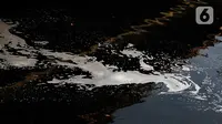Aliran Kali Bekasi yang tercemar limbah pabrik terlihat berwarna hitam pekat di Bendungan Bekasi, Jawa Barat, Rabu (20/9/2023). Selama tiga hari terakhir, pencemaran limbah di Kali Bekasi tak kunjung henti sehingga membuat air menjadi hitam pekat dan berbau. (merdeka.com/Imam Buhori)