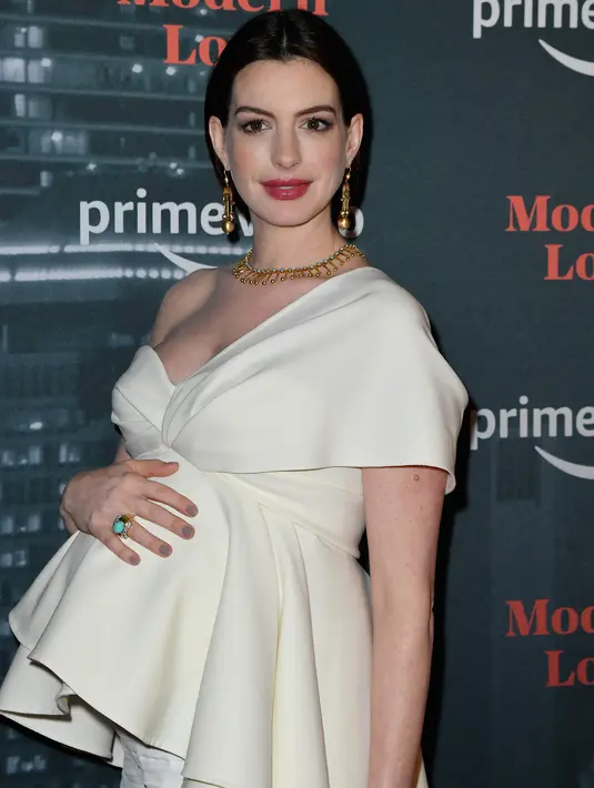 Aktris Anne Hathaway menghadiri pemutaran perdana "Modern Love," serial antologi romantis adaptasi dari rubrik New York Times di New York City, 10 Oktober 2019. Di karpet merah, Anne Hathaway memamerkan baby bump dalam balutan atasan model layer berwarna gading. (Angela Weiss / AFP)